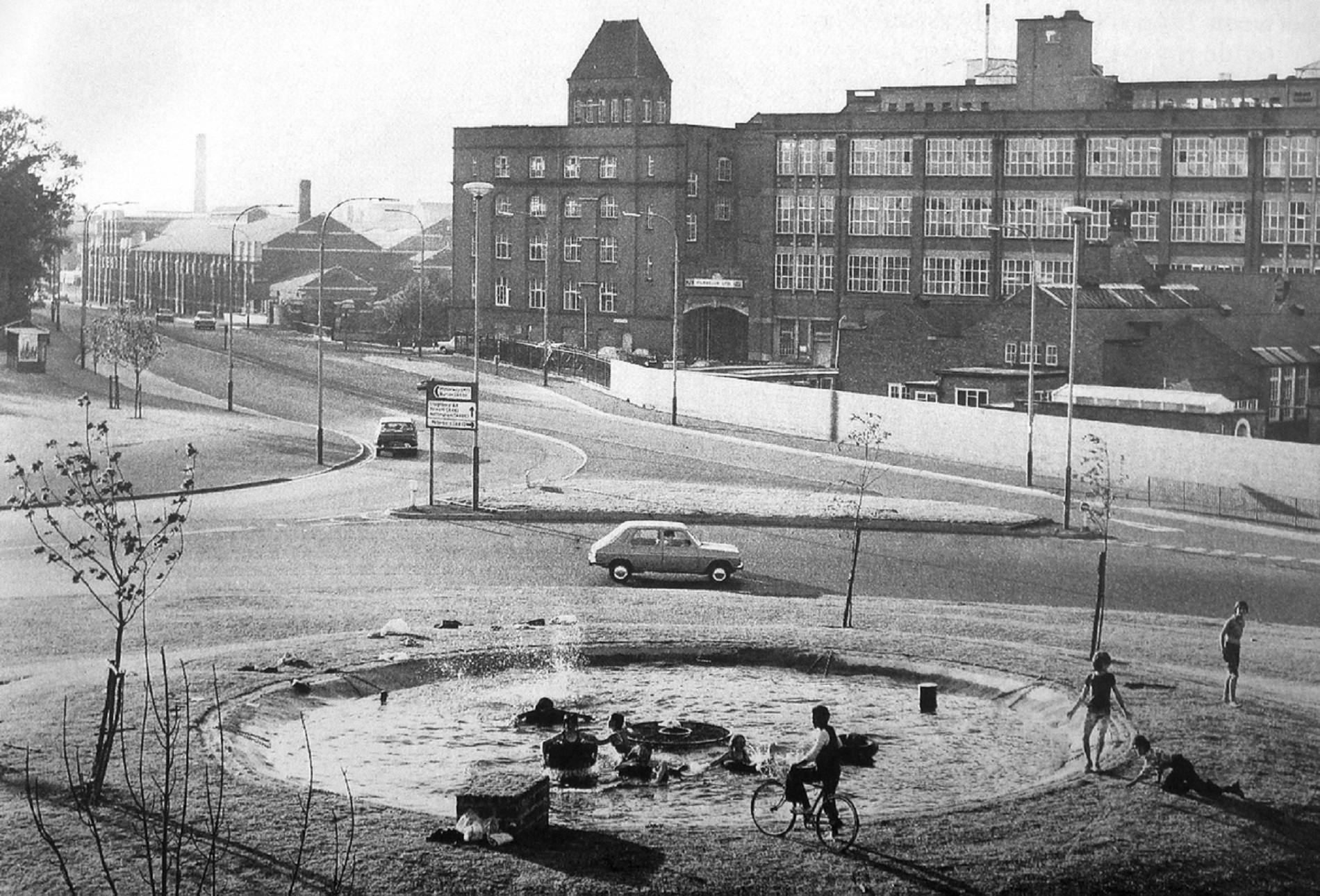 Children play in the water feature next to the flyover -
